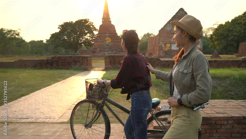 custom made wallpaper toronto digitalWoman riding a bicycle with front basket near Ayutthaya historical park in Thailand, a beautiful early morning time with bright sunrise light.