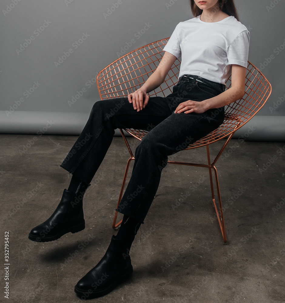 .posing. girl model posing in black jeans with a high waist and a belt