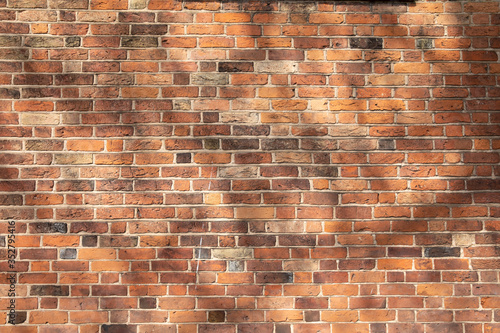 old brick wall with many shadows and different colors of bricks