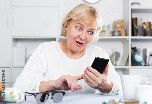 Mature woman with smartphone photo