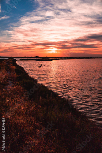 Saline di Cervia Natural Park and Wildlife Reserve at sunset, a wildlife and bird sanctuary, perfect for birdwatching. Walking along the levee of the saline while sun is going down.