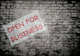 Grunge decayed faded brick wall background with open for business sign as retail businesses reopen following the worldwide pandemic shutdown
