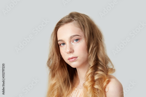Portrait of a beautiful young girl with bright wavy hair.