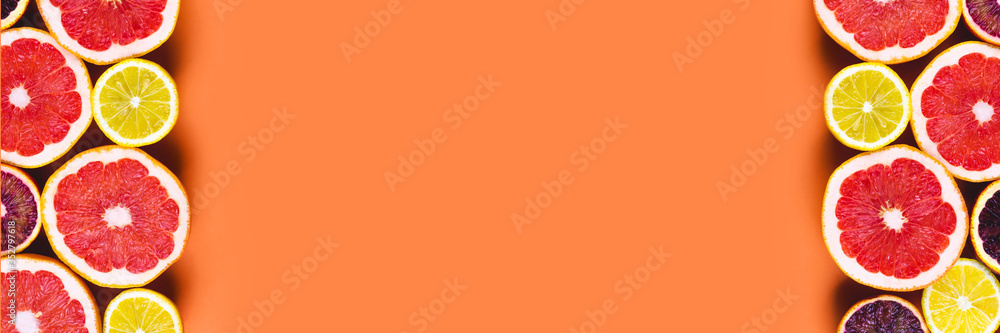 Many variety citrus fruits flat lay on orange background. Summer banner template, space for text Many variety citrus fruits flat lay on orange background. Summer banner template, space for text