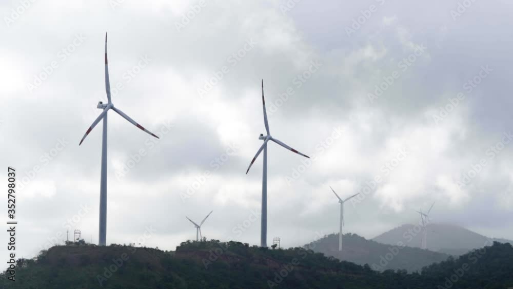 Wind turbine blade propeller rotate slowly at high hills farm location with trees. windmills alternative ecological energy on mountains in slow motion spinning. Wind turbine blade propeller rotate slowly at high hills farm location with trees. windmills alternative ecological energy on mountains in slow motion spinning.