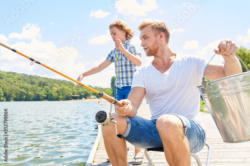 Vater und Sohn am See angeln zusammen