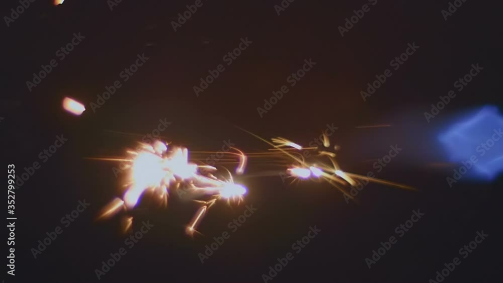 A jet of blue flame with bright yellow sparks in front of the flame, with beautiful lens flares, similar to a jet from a jet engine nozzle, on a black background. Closeup. Slow motion. High speed came