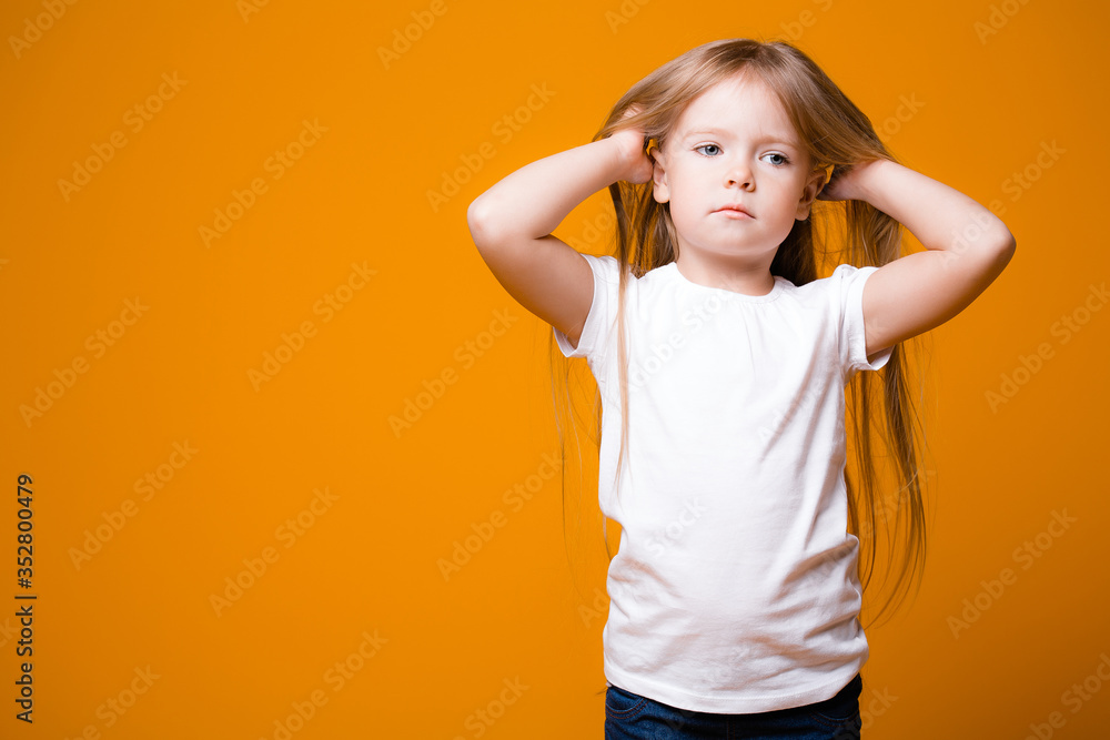 adorable girl 4-6 years old posing at camera isolated. shy little caucasian child. orange background adorable girl 4-6 years old posing at camera isolated. shy little caucasian child. orange background