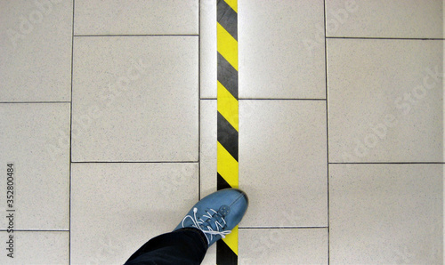striped dividing line on the floor to maintain distance
