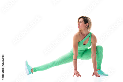 full body portrait of young sporty woman stretching before exercise isolated on white background.