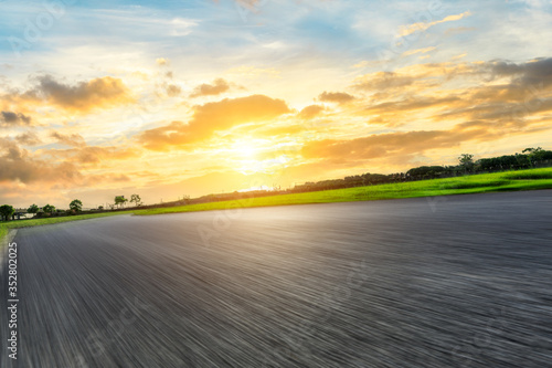 Fast moving asphalt highway and green forest at sunset. © ABCDstock