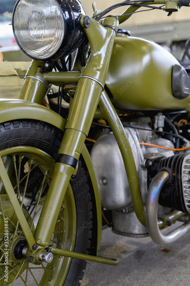 Fragment of an old military motorcycle. A khaki military motorcycle. Fragment of an old military motorcycle. A khaki military motorcycle.