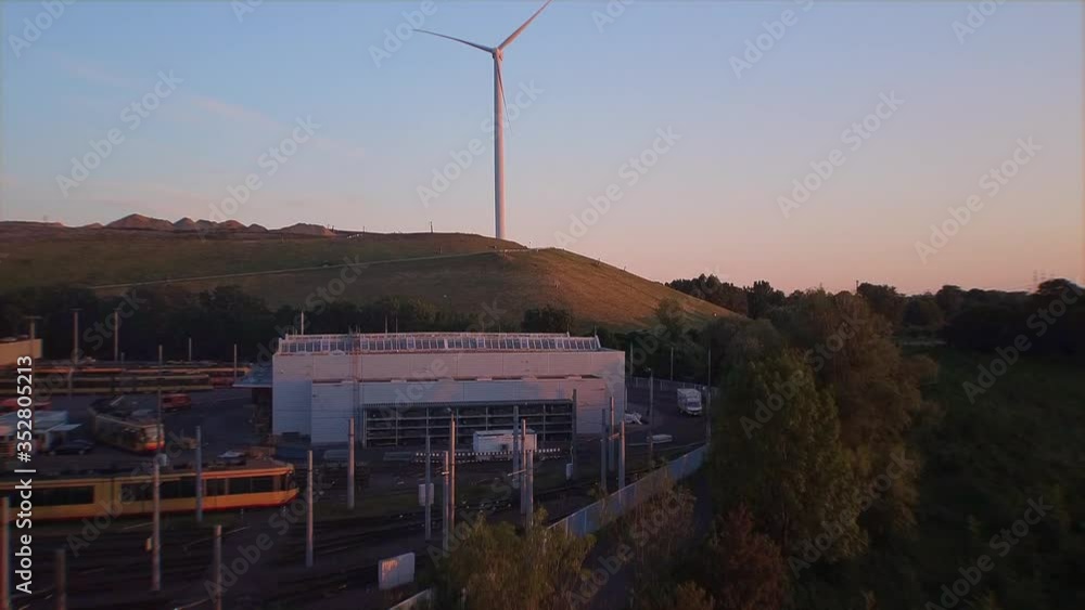 drone flying high towards an wind turbine in western Europe while sun is setting drone flying high towards an wind turbine in western Europe while sun is setting