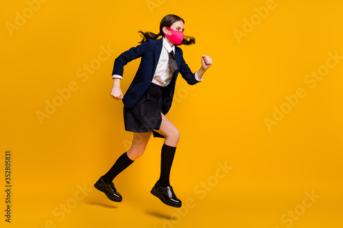 Full length body size view of her she nice attractive purposeful focused schoolgirl jumping wearing mask running fast hurry rush isolated over bright vivid shine vibrant yellow color background