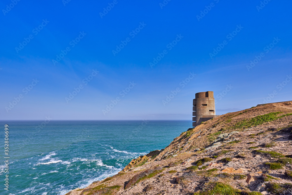 Image of German WW2 bunker and gun emplacement on the North West coast early sunny morning with blue sky, Jersey, Channel Islands, uk
