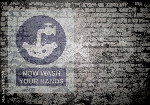 Grunge decayed faded brick wall background with now wash your hands message sign to stop the spread of the worldwide pandemic