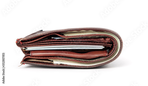Old brown leather wallet with banknotes and credit cards isolated on white background. File contains a path to isolation.