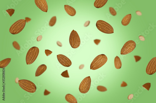 Falling almonds isolated on a colored background with clipping path as package design element and advertising. Flying food. Top view.