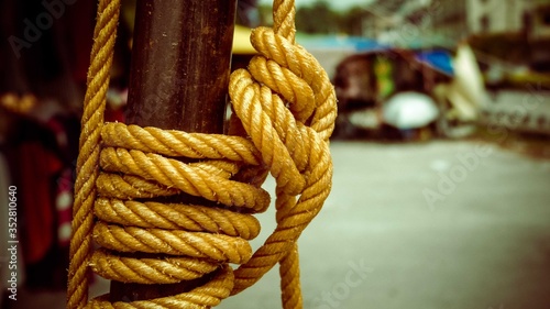 brown thick rope tying wooden thick pole