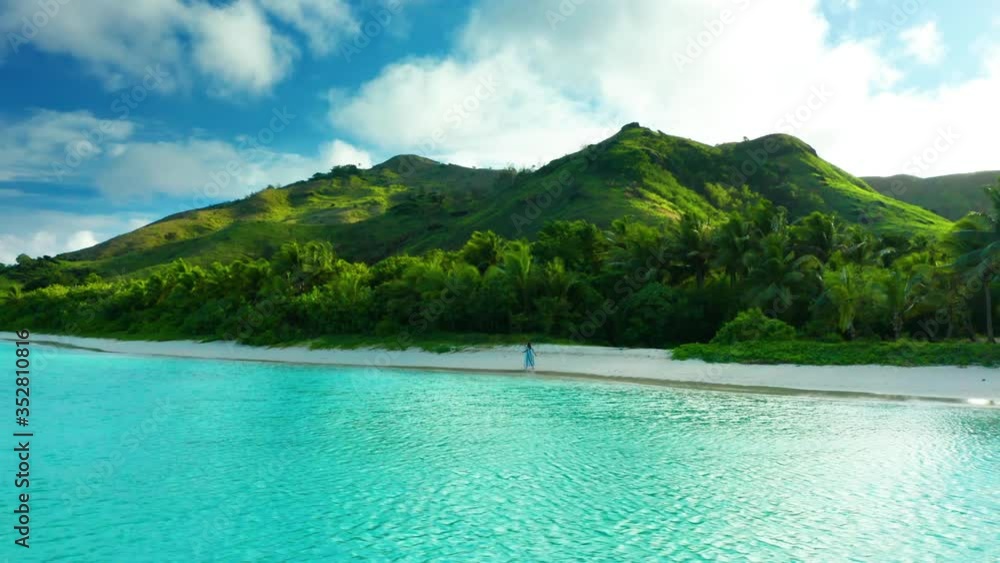 Girl walking on perfect tropical island beach during bright morning light, drone Girl walking on perfect tropical island beach during bright morning light, drone