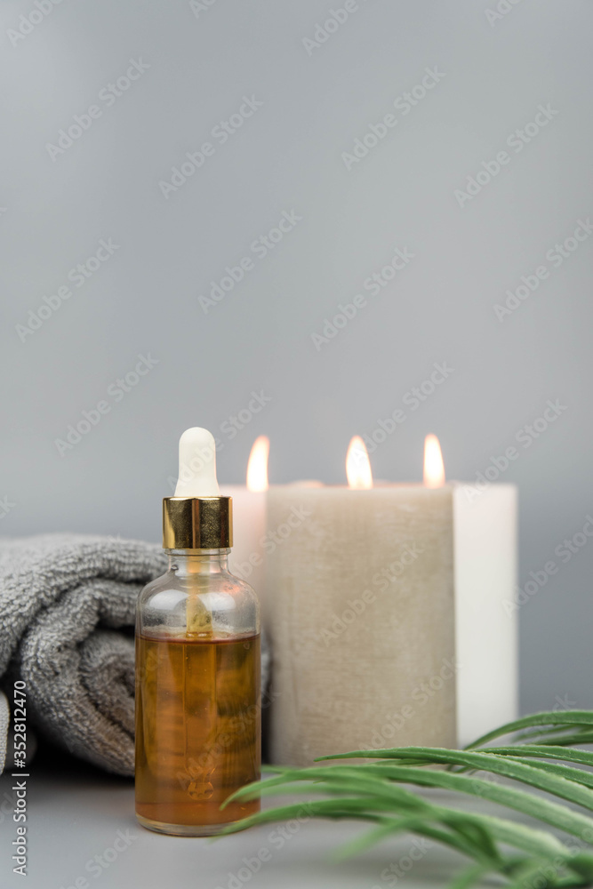 Towel with aromatic candles and bottle with natural organic oil essence serum. Aromatherapy and beauty. Concept set of harmony, balance and meditation, spa, massage, relax, beauty spa treatment. Towel with aromatic candles and bottle with natural organic oil essence serum. Aromatherapy and beauty. Concept set of harmony, balance and meditation, spa, massage, relax, beauty spa treatment.