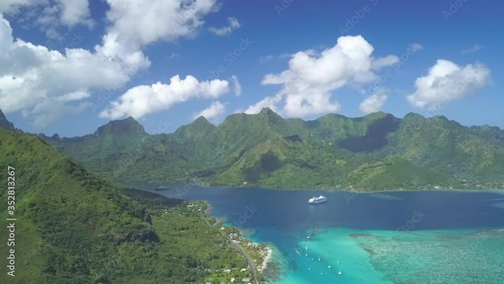 High flying drone over tropical blue water bay with cruise ship and island mountains High flying drone over tropical blue water bay with cruise ship and island mountains