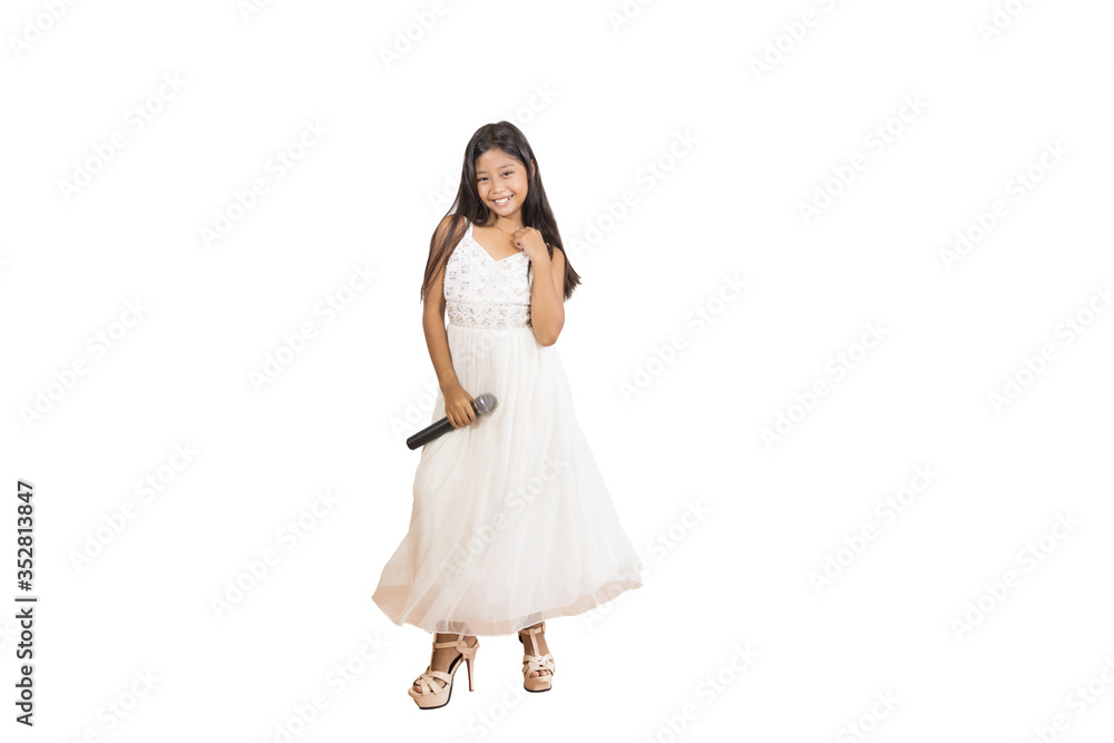 Portrait of a cute Asian elementary school girl with long hair wearing a white evening dress with a microphone used for singing. An isolated image with white background Portrait of a cute Asian elementary school girl with long hair wearing a white evening dress with a microphone used for singing. An isolated image with white background