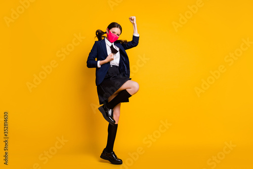 Full length body size view of her she nice attractive lucky schoolgirl jumping rejoicing accomplishment attainment wearing mask isolated over bright vivid shine vibrant yellow color background