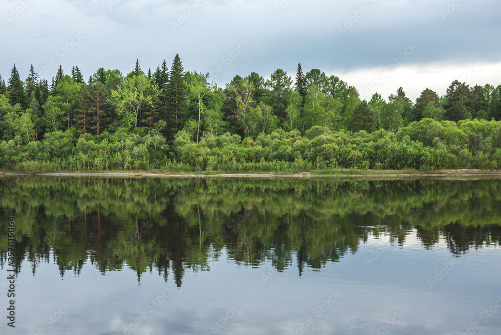A landscape of dense green forest that is reflection in the river and hills. Majestic and beautiful Siberian nature A landscape of dense green forest that is reflection in the river and hills. Majestic and beautiful Siberian nature