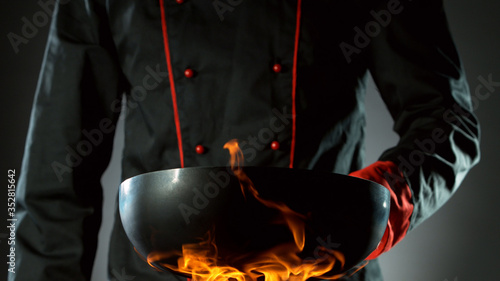 Closeup of chef holding empty wok pan photo