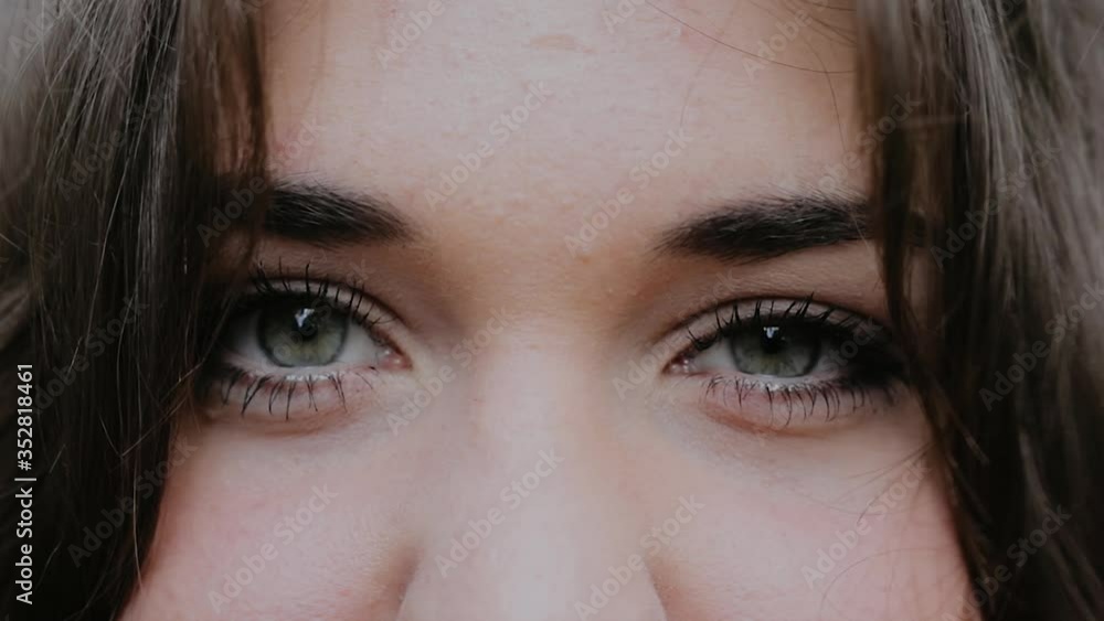 Close-Up of Young Woman’s Blinking Eyes, windy hair, Slow Motion Macro Shot of Female Eyes Opening and Closing with Natural Long Eyelashes. Close-Up of Young Woman’s Blinking Eyes, windy hair, Slow Motion Macro Shot of Female Eyes Opening and Closing with Natural Long Eyelashes.