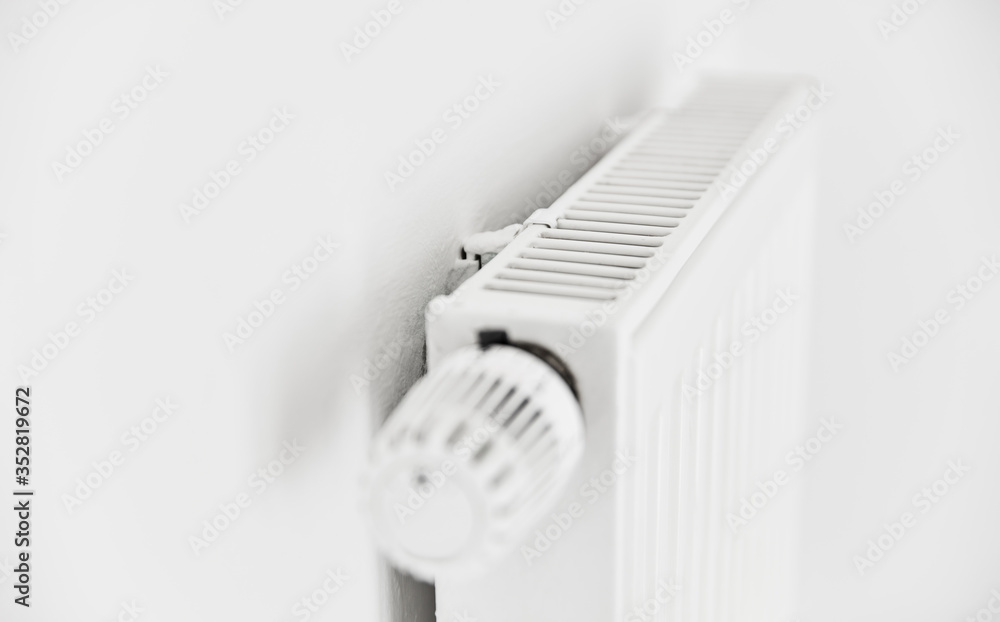 Heizung mit Plattenheizkörper und Thermostat an Wand Heizung mit Plattenheizkörper und Thermostat an Wand