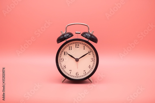 Alarm clock on pink background with copy space for you design.