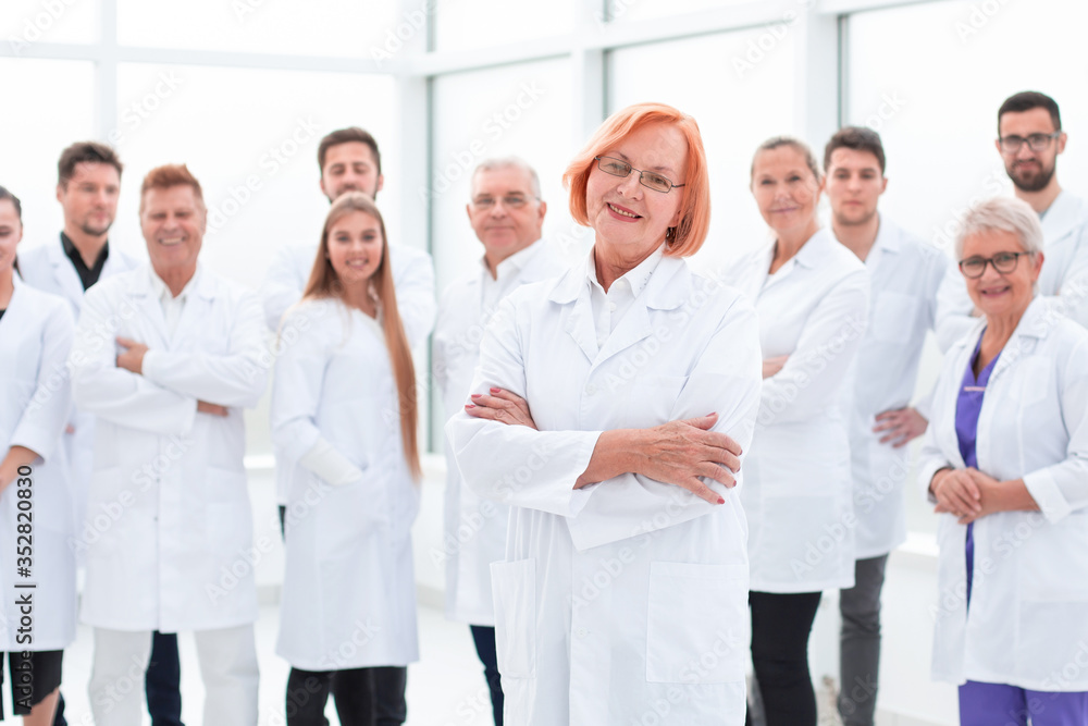 senior female doctor standing in front of her colleagues. senior female doctor standing in front of her colleagues.