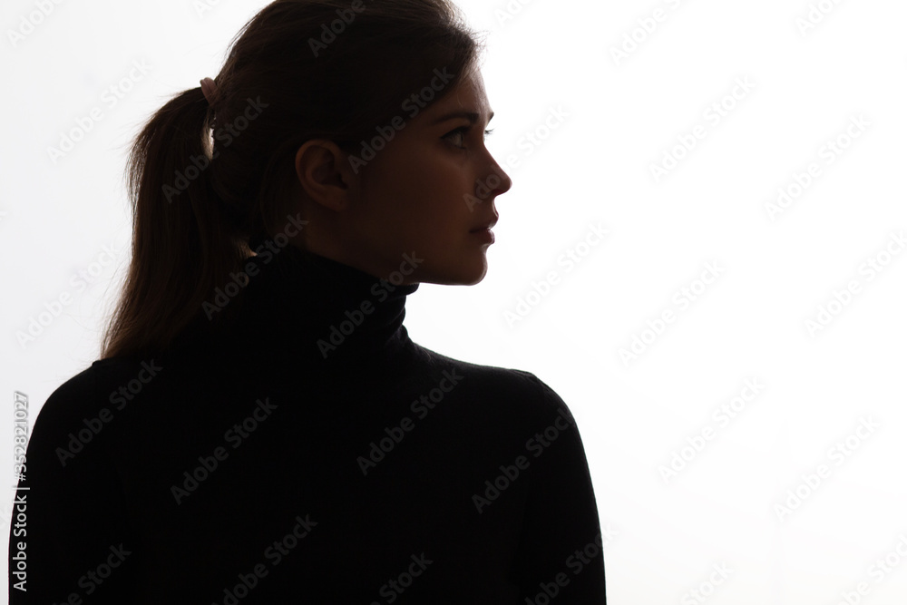 silhouette girl portrait with piercing look on white isolated background, young woman in black clothes