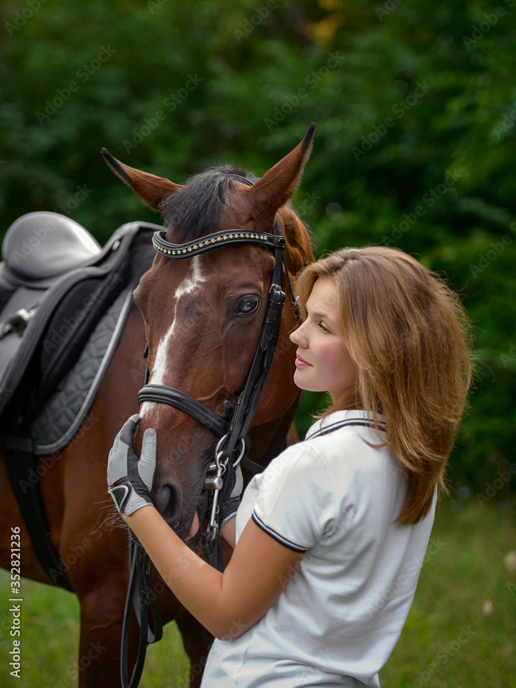 Obraz premium Beautiful young girl rider and her horse