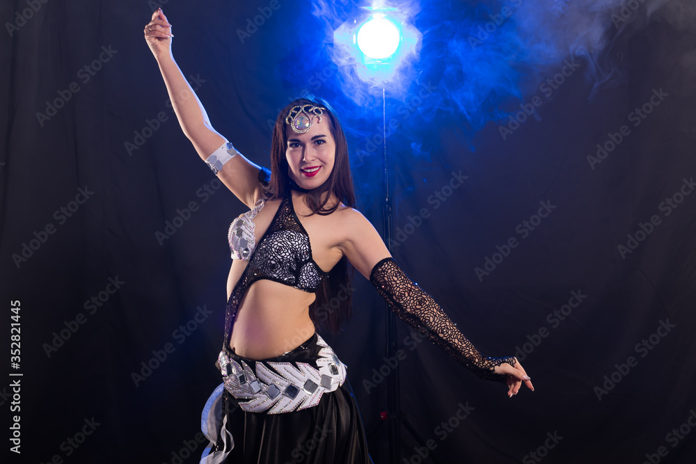 Belly dancer. Young attractive woman dancing tribal fusion on the stage. Oriental exotic dance. Belly dancer. Young attractive woman dancing tribal fusion on the stage. Oriental exotic dance.