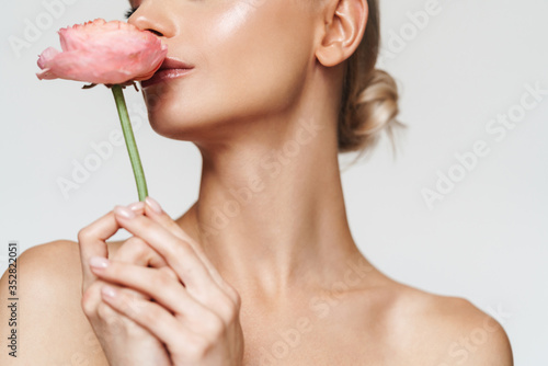 Cropped image of beautiful seductive shirtless woman posing with flower