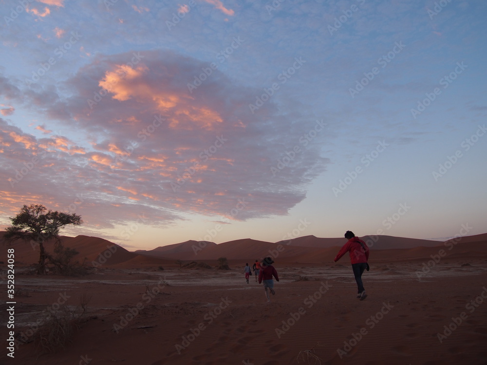 Women running towards Deadvlei to watch the morning sun, Namibia