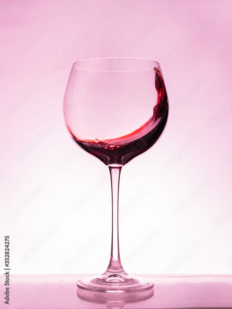 Red wine splashing a wave in a glass. Red wine splashing a wave in a glass.