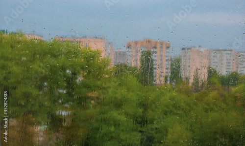 Rainy day in the city-drops on the window, view from the window on the city