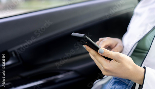 close up businesswoman hand holding smartphone to checking job and reading mail inside car before go to meeting at company for business and transport concept