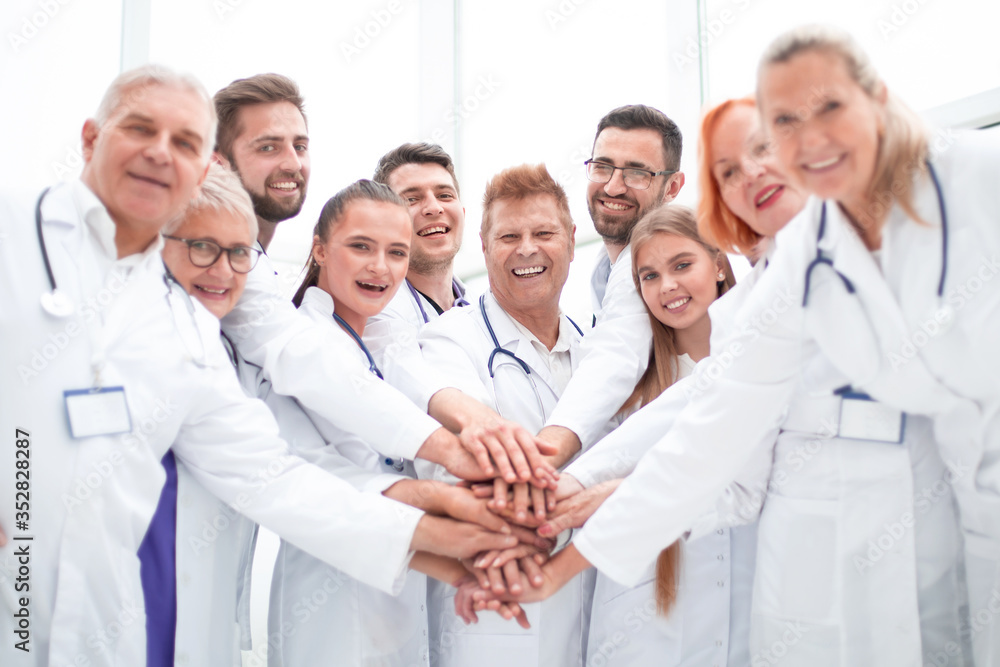 large group of doctors put their hands together. large group of doctors put their hands together.