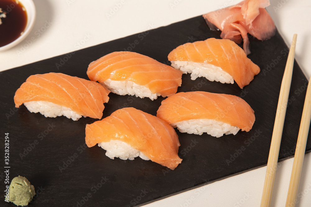 Salmon nigiri dish with wasabi and ginger on white background Salmon nigiri dish with wasabi and ginger on white background