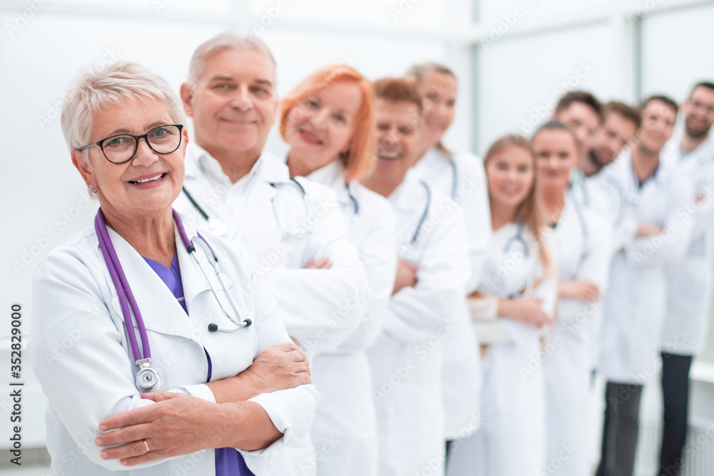senior female doctor standing in front of her colleagues. senior female doctor standing in front of her colleagues.