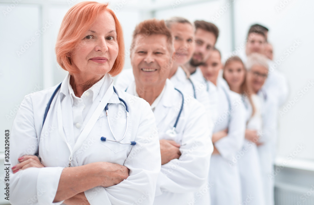 close up. Mature female doctor standing in front of her colleagues. close up. Mature female doctor standing in front of her colleagues.