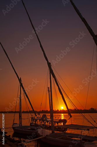 Fototapeta Naklejka Na Ścianę i Meble -  Traditional egyptian felluca sailing boats moored on Nile at sunset
