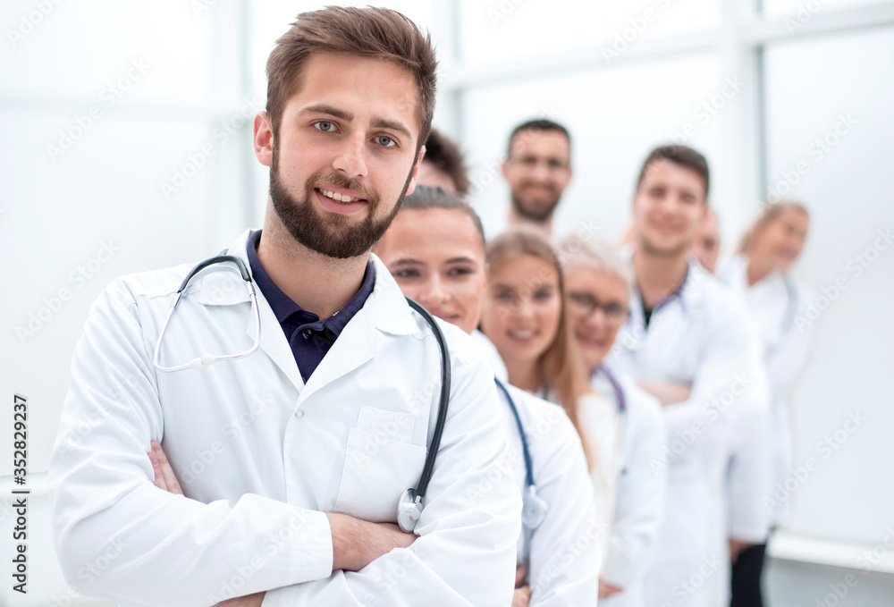close up. confident male doctor standing in front of his colleagues. close up. confident male doctor standing in front of his colleagues.