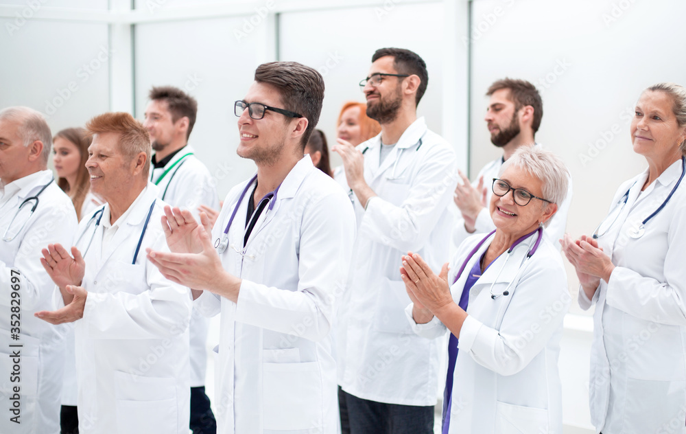 large group of medical practitioners applauding together. large group of medical practitioners applauding together.