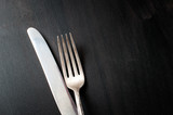 vintage silver knife and fork on dark background, horizontal image